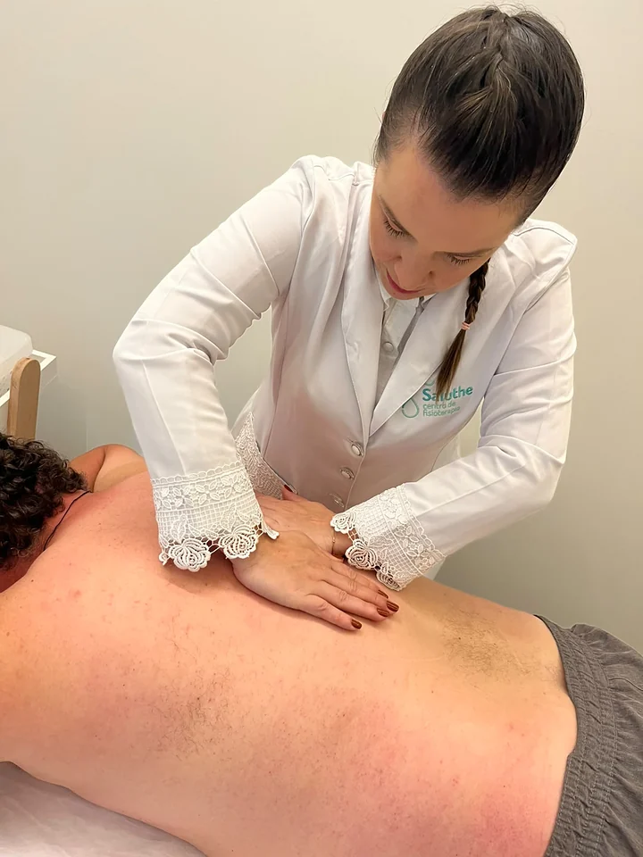 Dra. Rafaela Rigo faz terapia manual nas costas de um paciente